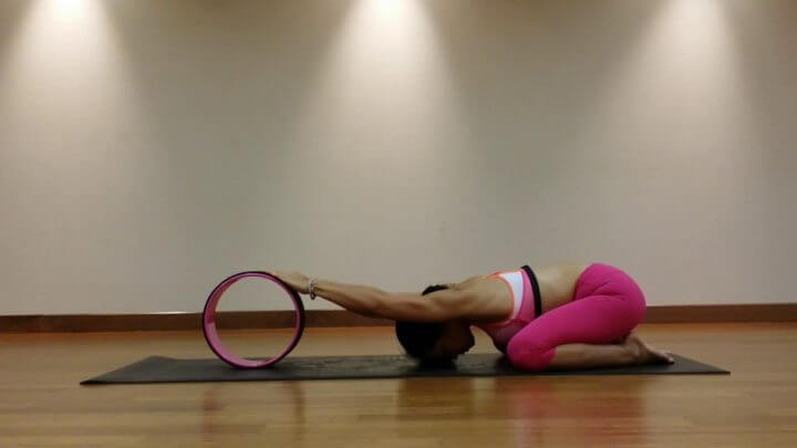 Pose del niño con la rueda de yoga