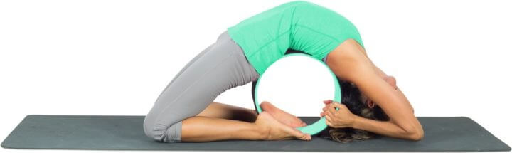 Pose de la paloma con rueda de yoga