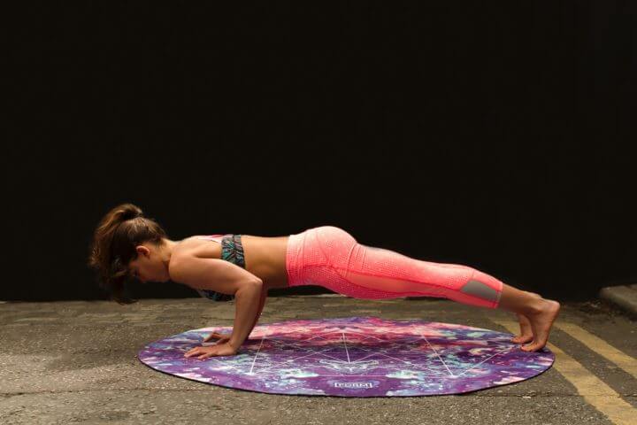Postura del tablón o plancha con rueda de yoga