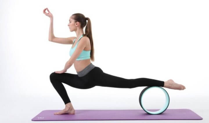 Postura de la luna creciente con rueda de yoga